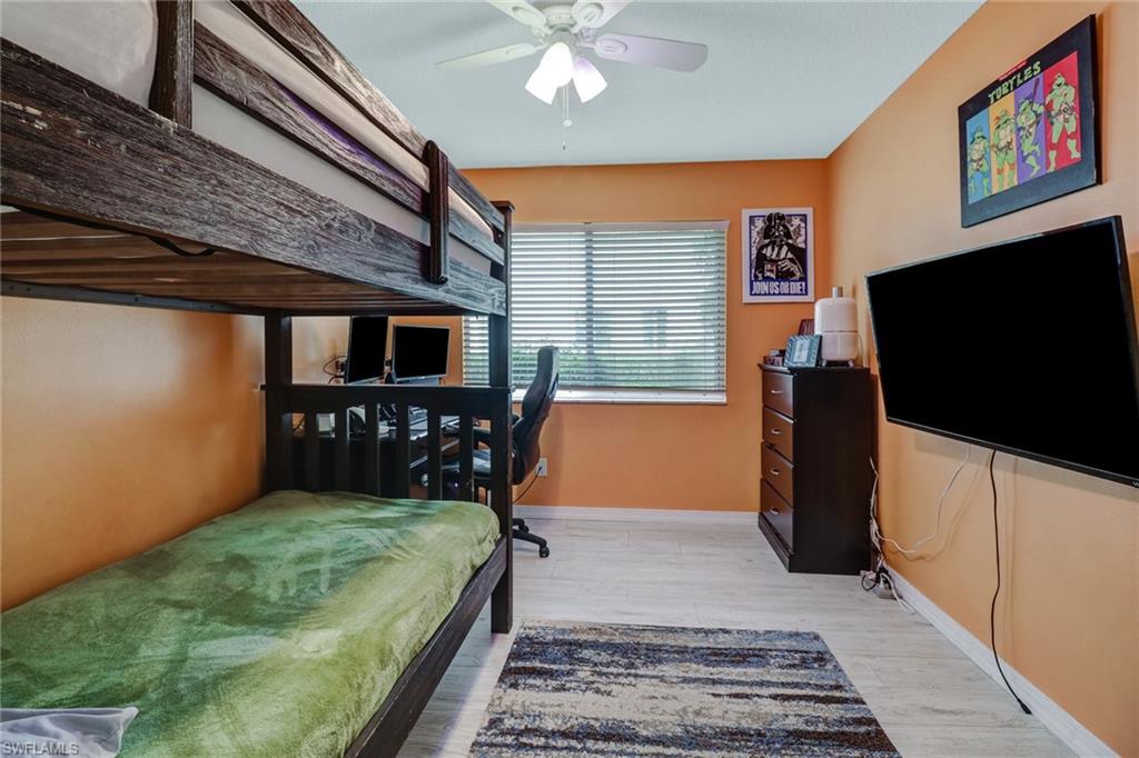 7750 Jewel Lane, Unit 101 Naples, FL 34109 - Photo 22 of 28 a bedroom with furniture and flat screen tv
