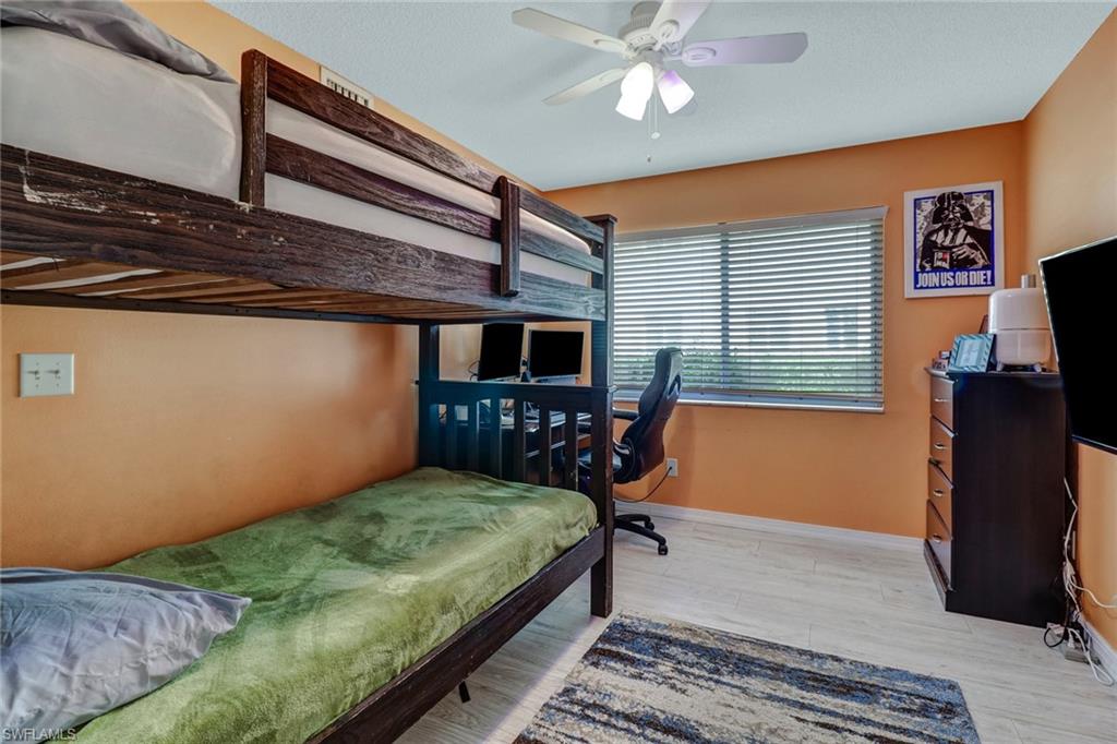 7750 Jewel Lane, Unit 101 Naples, FL 34109 - Photo 23 of 28 a bedroom with a bed window and a flat screen tv