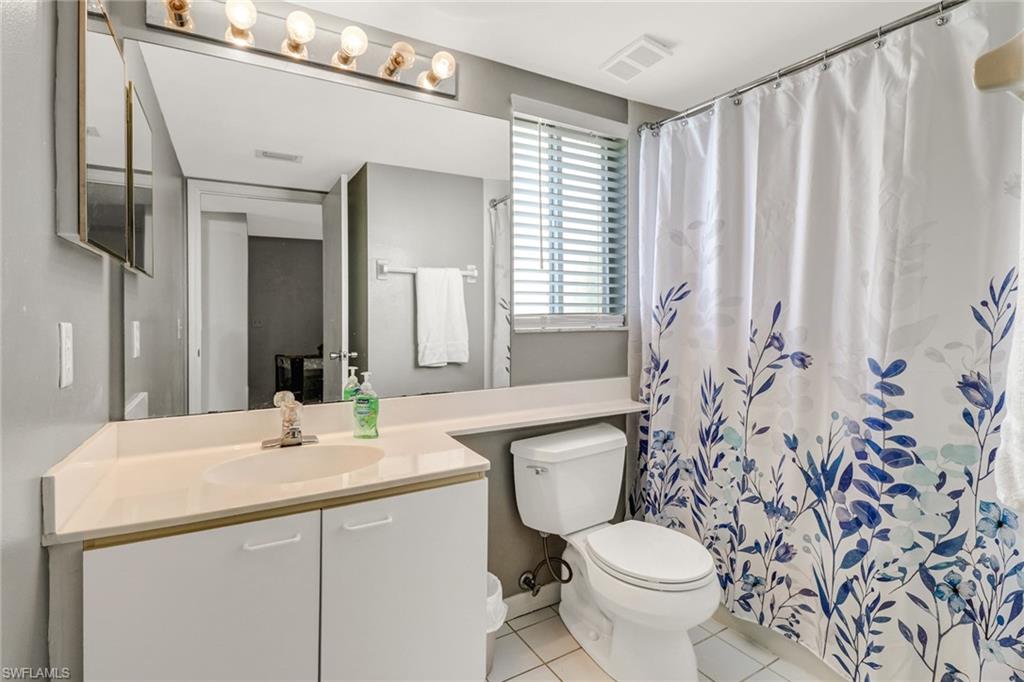 7750 Jewel Lane, Unit 101 Naples, FL 34109 - Photo 24 of 28 a bathroom with a toilet sink and mirror
