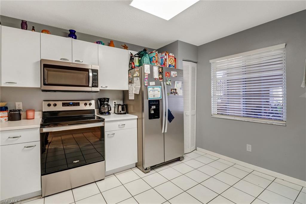 7750 Jewel Lane, Unit 101 Naples, FL 34109 - Photo 4 of 28 a kitchen with stainless steel appliances granite countertop a stove a microwave and a refrigerator
