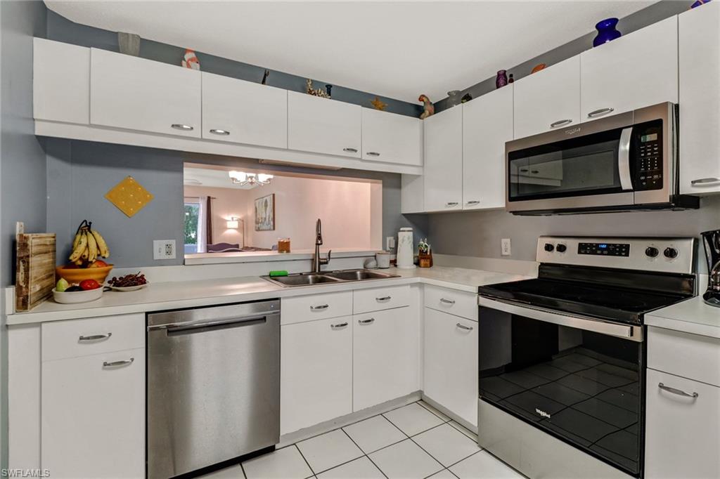 7750 Jewel Lane, Unit 101 Naples, FL 34109 - Photo 5 of 28 a kitchen with white cabinets and appliances