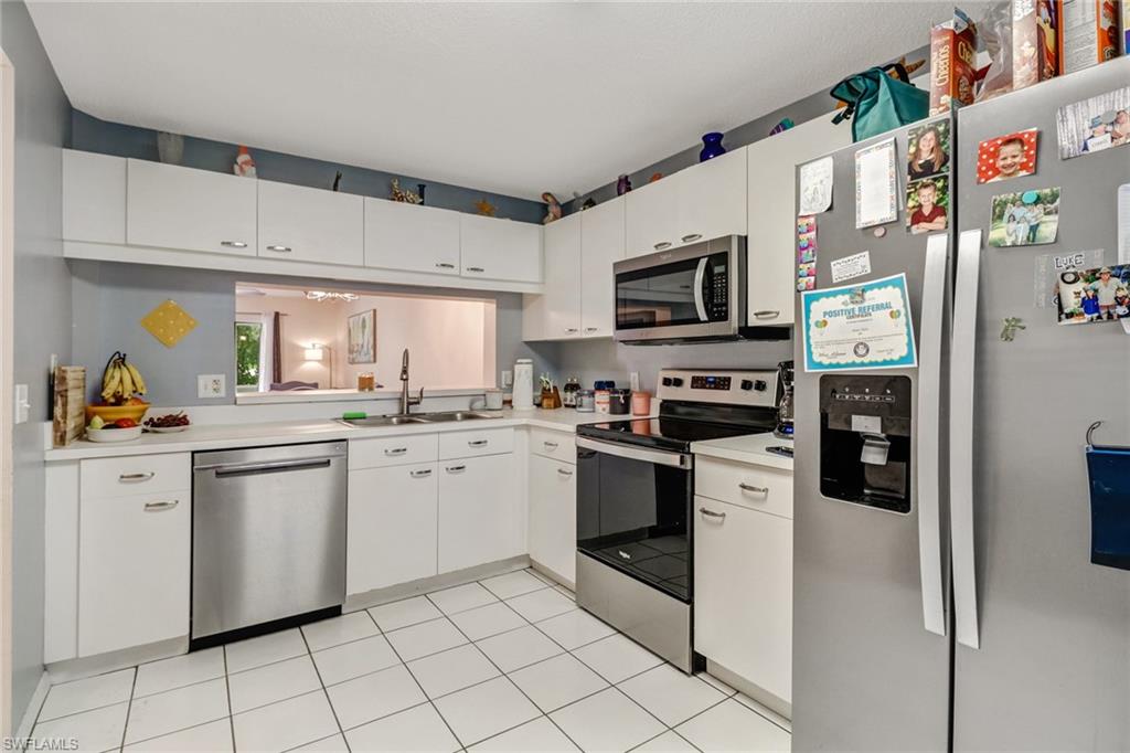7750 Jewel Lane, Unit 101 Naples, FL 34109 - Photo 6 of 28 a kitchen with stainless steel appliances granite countertop a refrigerator and a stove top oven