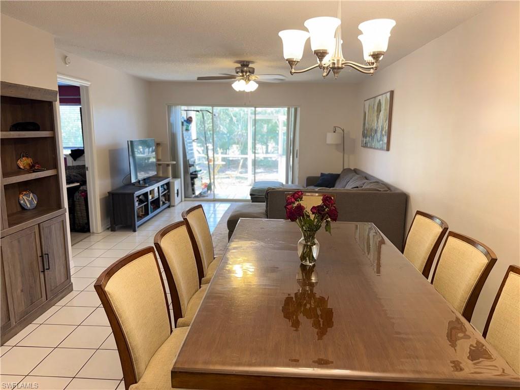 7750 Jewel Lane, Unit 101 Naples, FL 34109 - Photo 8 of 28 a view of a dining room with furniture a chandelier and wooden floor