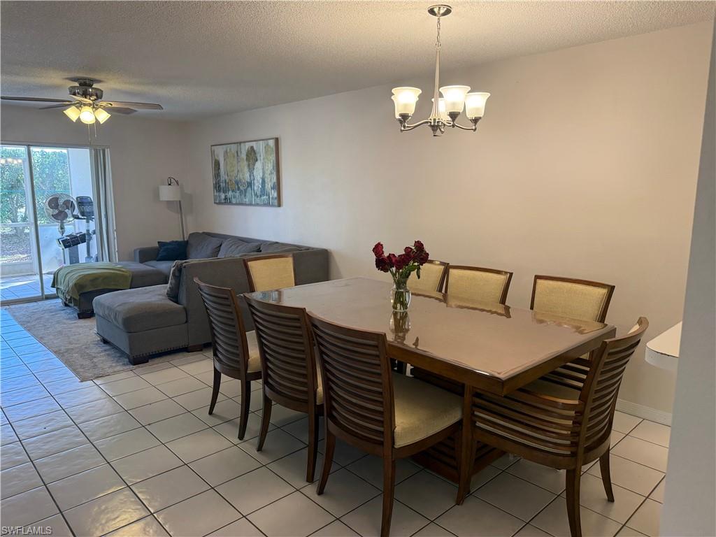 7750 Jewel Lane, Unit 101 Naples, FL 34109 - Photo 9 of 28 a view of a dining room with furniture and chandelier