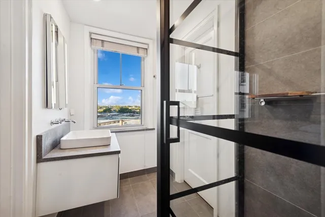 a kitchen with a sink and white cabinets with wooden floor