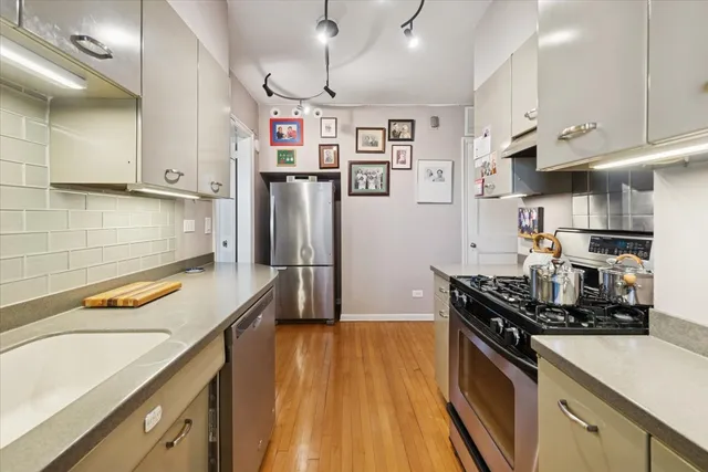 a kitchen with stainless steel appliances granite countertop a refrigerator and a stove top oven
