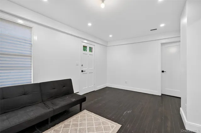 a living room with a couch and a wooden floor