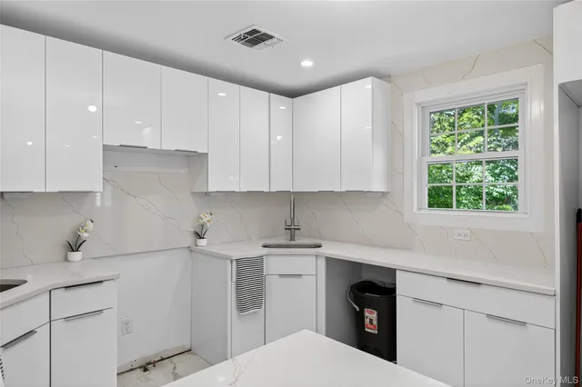 a kitchen with a sink window and cabinets