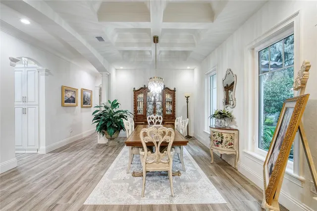 a view of a hallway with wooden floor and a dining room