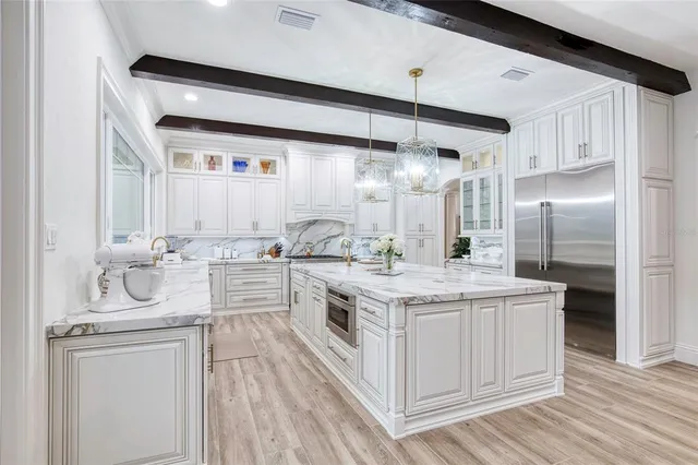 a kitchen with white cabinets and a window