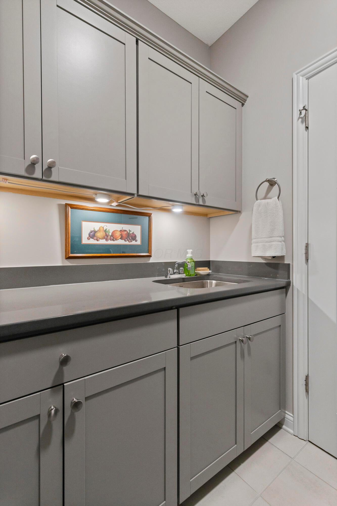 3604 Whispering Pines Road Delaware, OH 43015 - Photo 20 of 58 Built in soft grey cabinets and laundry sink in laundry room.