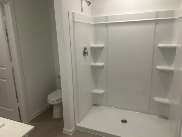 a bathroom with a toilet and shower