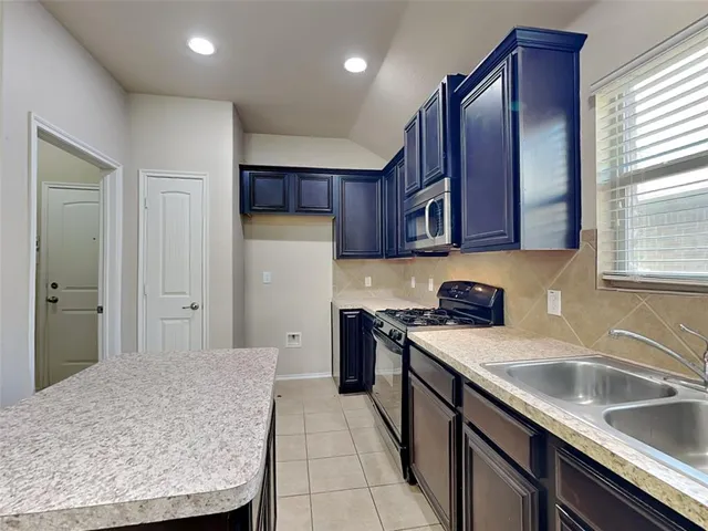 a kitchen with a sink stove and refrigerator