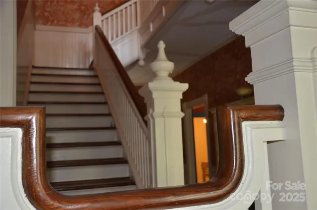 a view of staircase with lots of frames on deck and a wooden floor