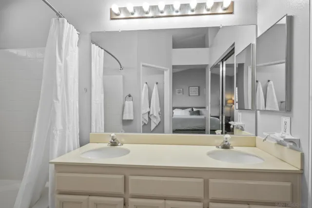 a bathroom with a double vanity sink mirror double and bathtub
