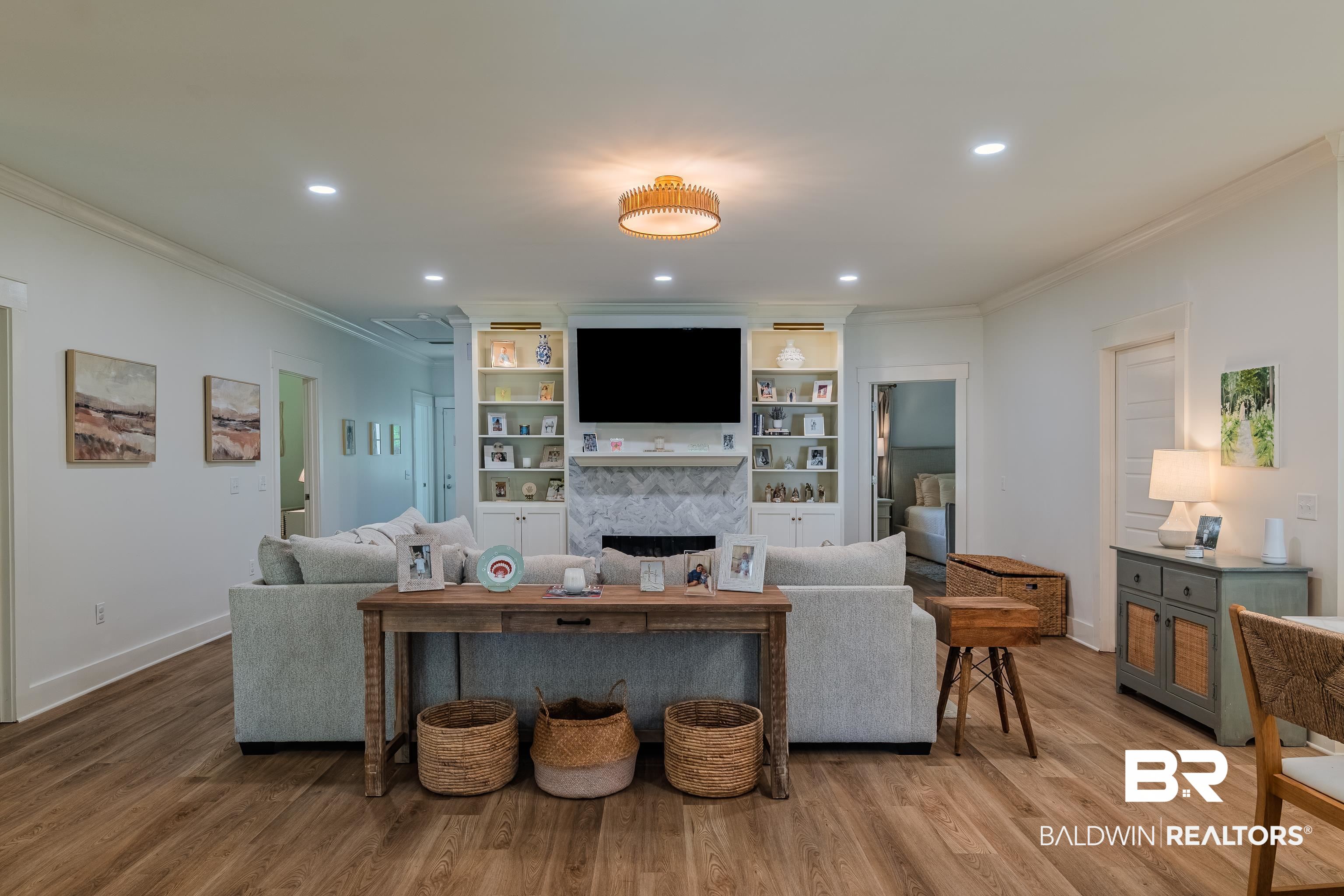19121 Boothe Road Fairhope, AL 36532 - Photo 14 of 41 Living room with light wood finished floors, crown molding, recessed lighting, a fireplace, and built in features