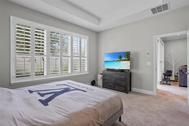 a bedroom with a bed and a large window