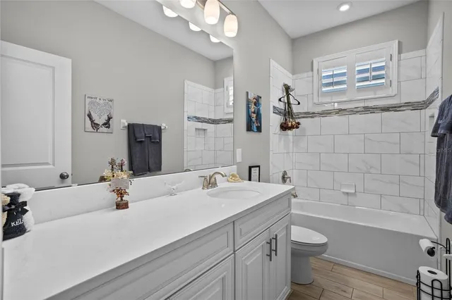 a bathroom with a sink a toilet a mirror and shower