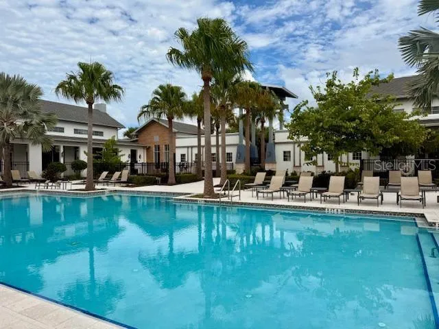 a view of a patio with couches chairs and swimming pool with a barbeque grill