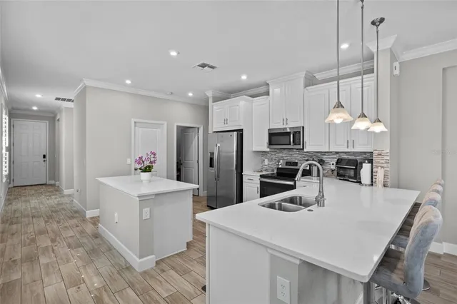 a kitchen with white cabinets and stainless steel appliances