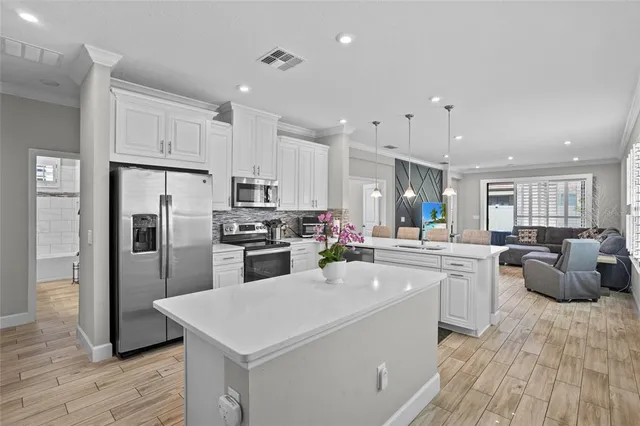 a kitchen with white cabinets and stainless steel appliances