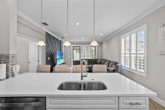 a view with a dining table chairs wooden floor and a chandelier