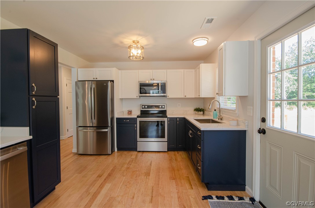 15073 Neck Trail Doswell, VA 23047 - Photo 16 of 50 a kitchen with stainless steel appliances granite countertop a refrigerator a sink dishwasher a stove and white countertops with wooden floor