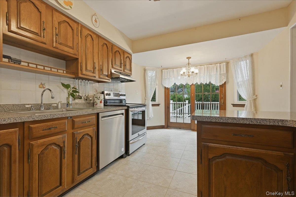 17 Avon Road Farmingdale, NY 11735 - Photo 10 of 46 a kitchen with stainless steel appliances granite countertop a stove a sink and a refrigerator with wooden cabinets