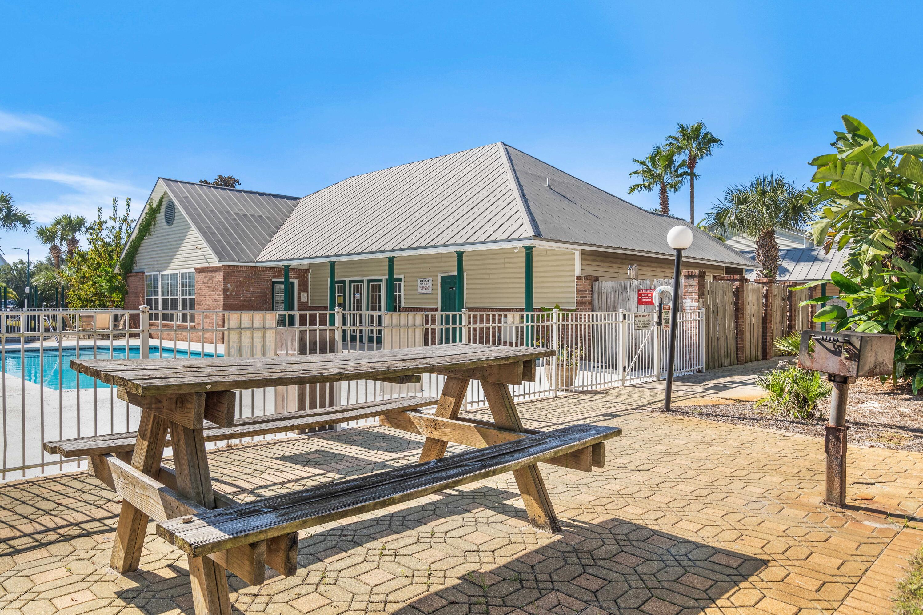 4100 Dancing Cloud Court, Unit 287 Destin, FL 32541 - Photo 24 of 26 a roof deck with table and chairs under an umbrella