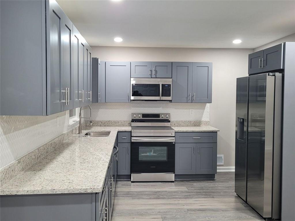 4059 Canby Lane Decatur, GA 30035 - Photo 5 of 18 a kitchen with stainless steel appliances granite countertop a sink stove and refrigerator