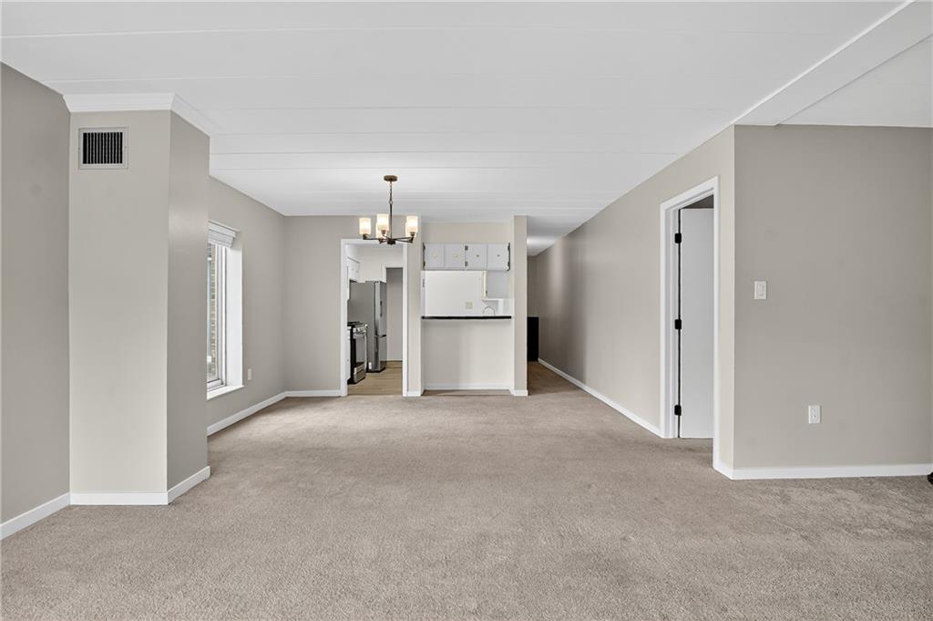 5 Bayard Road, Unit 500 Pittsburgh, PA 15213 - Photo 11 of 45 an empty room with a kitchen and a refrigerator