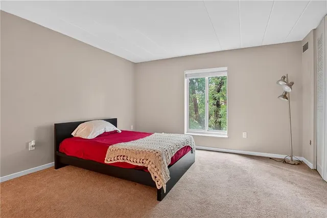 a bedroom with a bed and a large window