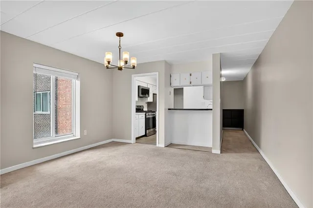 an empty room with windows and chandelier