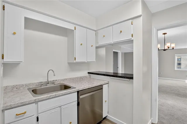 a kitchen with stainless steel appliances white cabinets and a stove top oven
