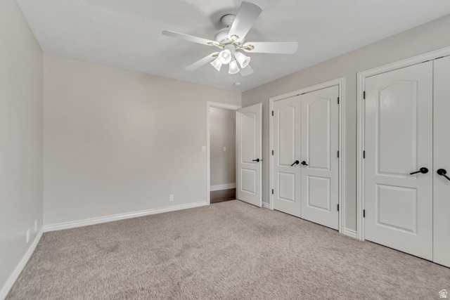 2154 Wasatch Boulevard Sandy, UT 84092 - Photo 12 of 55 Unfurnished bedroom with two closets, light carpet, and ceiling fan