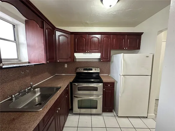 a kitchen with a refrigerator sink and cabinets