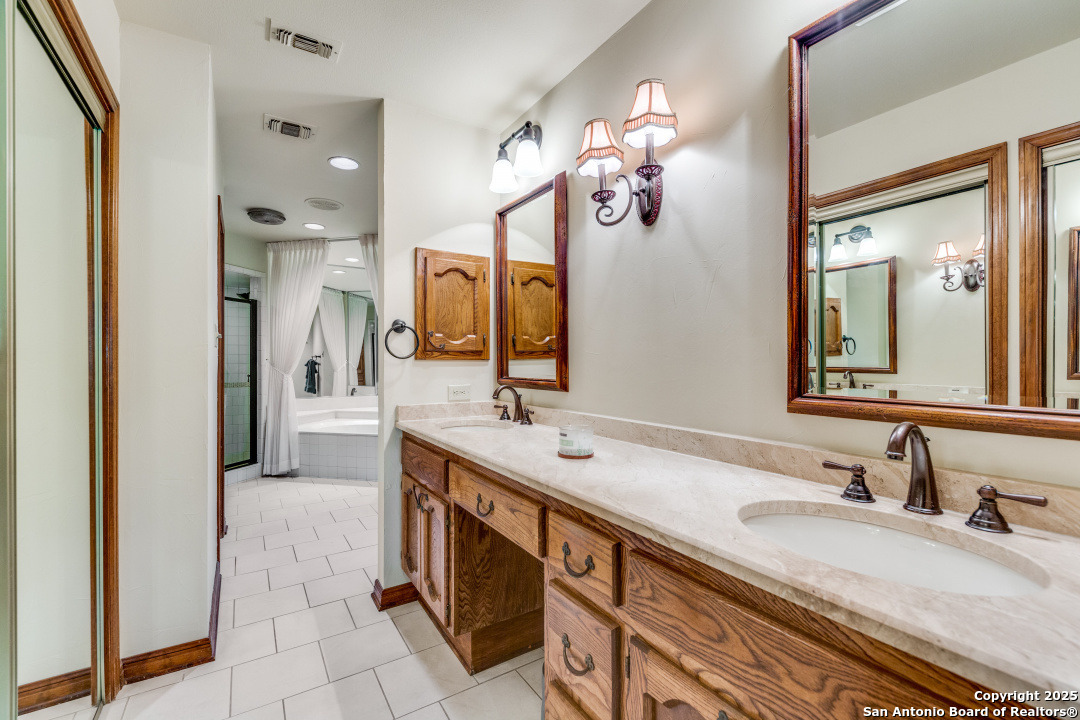 122 Cliffdwellers Path Boerne, TX 78006 - Photo 13 of 35 a bathroom with a sink double vanity granite and a mirror