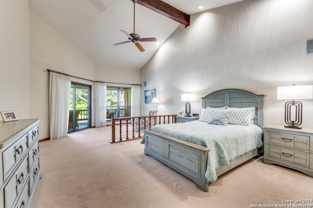 122 Cliffdwellers Path Boerne, TX 78006 - Photo 10 of 35 a spacious bedroom with a bed a chandelier and dresser