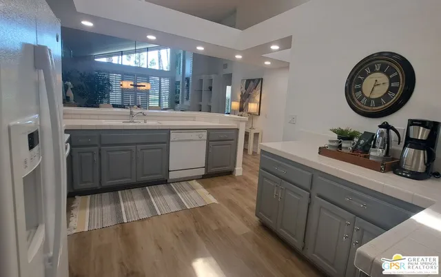 a kitchen with stainless steel appliances a refrigerator and a wooden cabinets