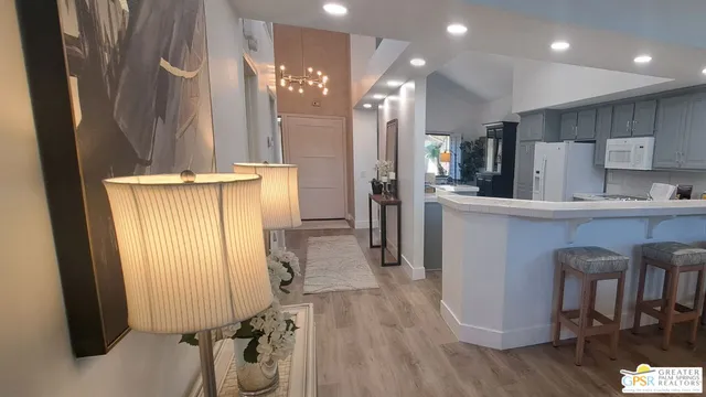 a kitchen with kitchen island stainless steel appliances a dining table chairs and wooden floor