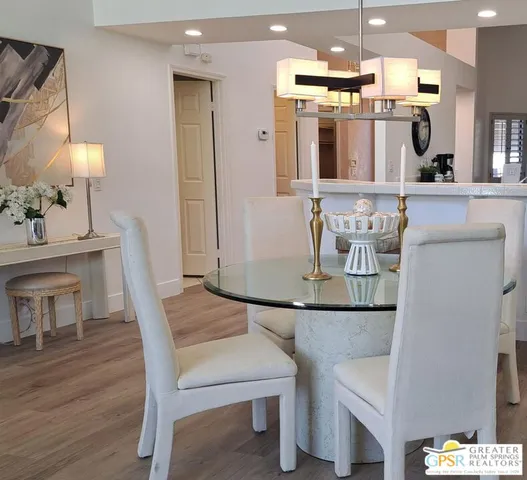 a living room with furniture kitchen view and a chandelier