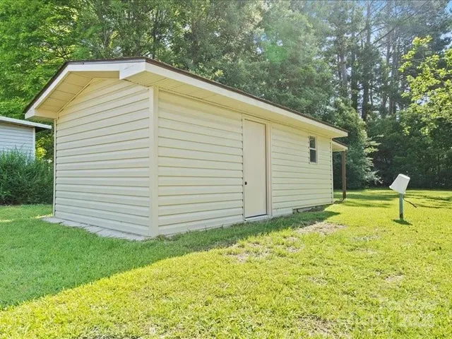 a backyard of a house with plants and wooden fence
