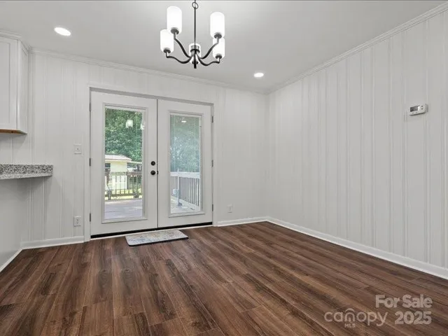 a view of empty room with wooden floor and window