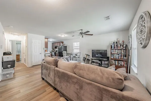 a living room with furniture and a wooden floor
