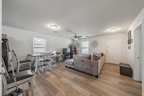 a living room with furniture and a wooden floor