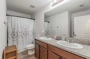a bathroom with a granite countertop sink toilet and shower