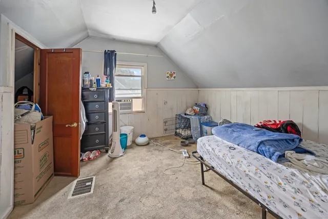 a view of a backyard with table and chairs potted plants and large tree