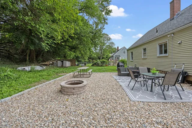 a backyard of a house with table and chairs