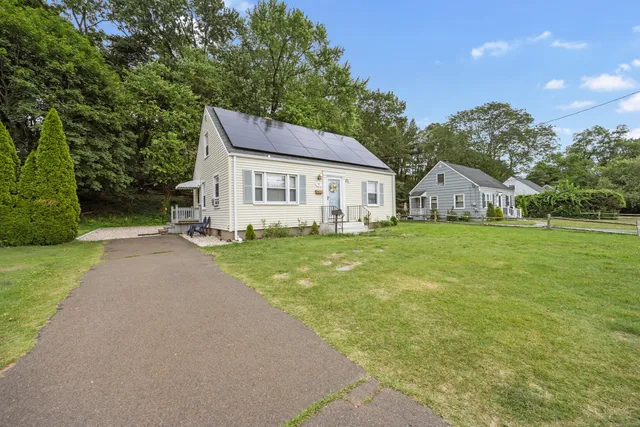a view of a house with a yard and pathway