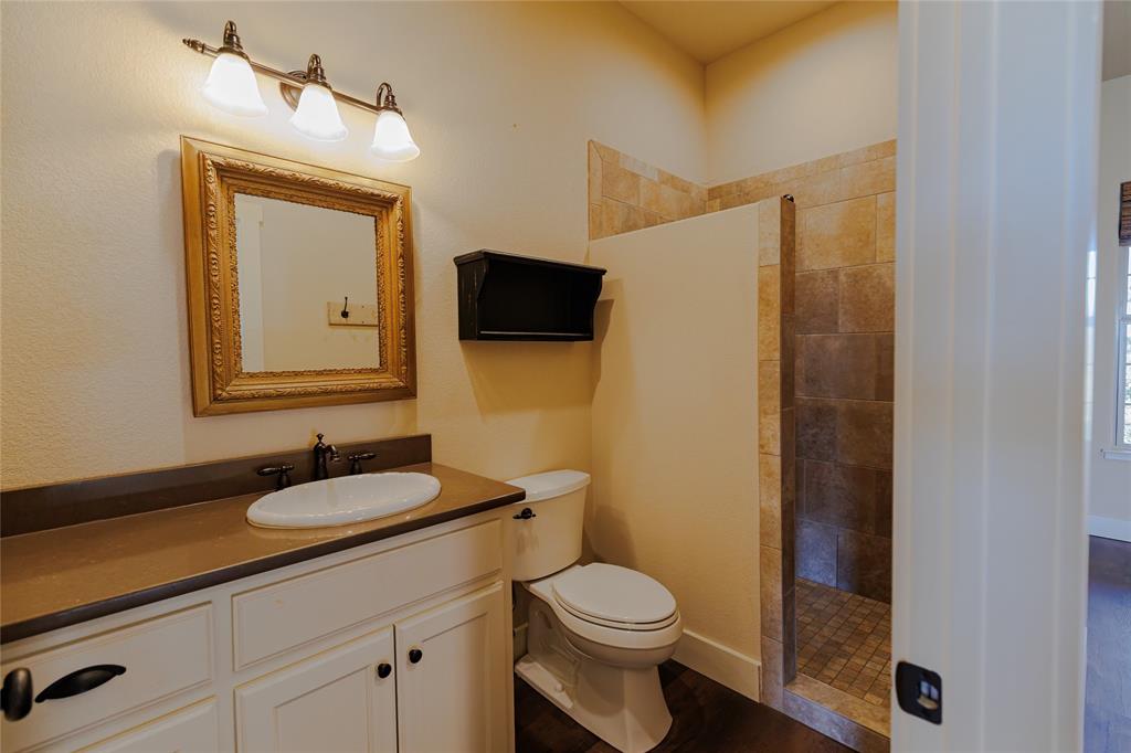 1433 County Road 1180 Decatur, TX 76234 - Photo 14 of 36 a bathroom with a granite countertop sink toilet and mirror